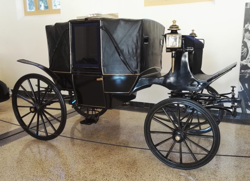 Vanhat, katetut, hevosvetoiset, mustat kärryt.