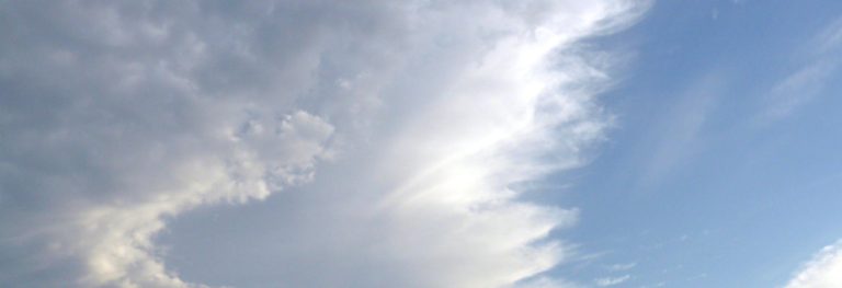 Valkoisia pilviä sinisellä taivaalla.